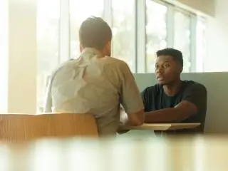 therapy-and-coaching two people sat at a table talking